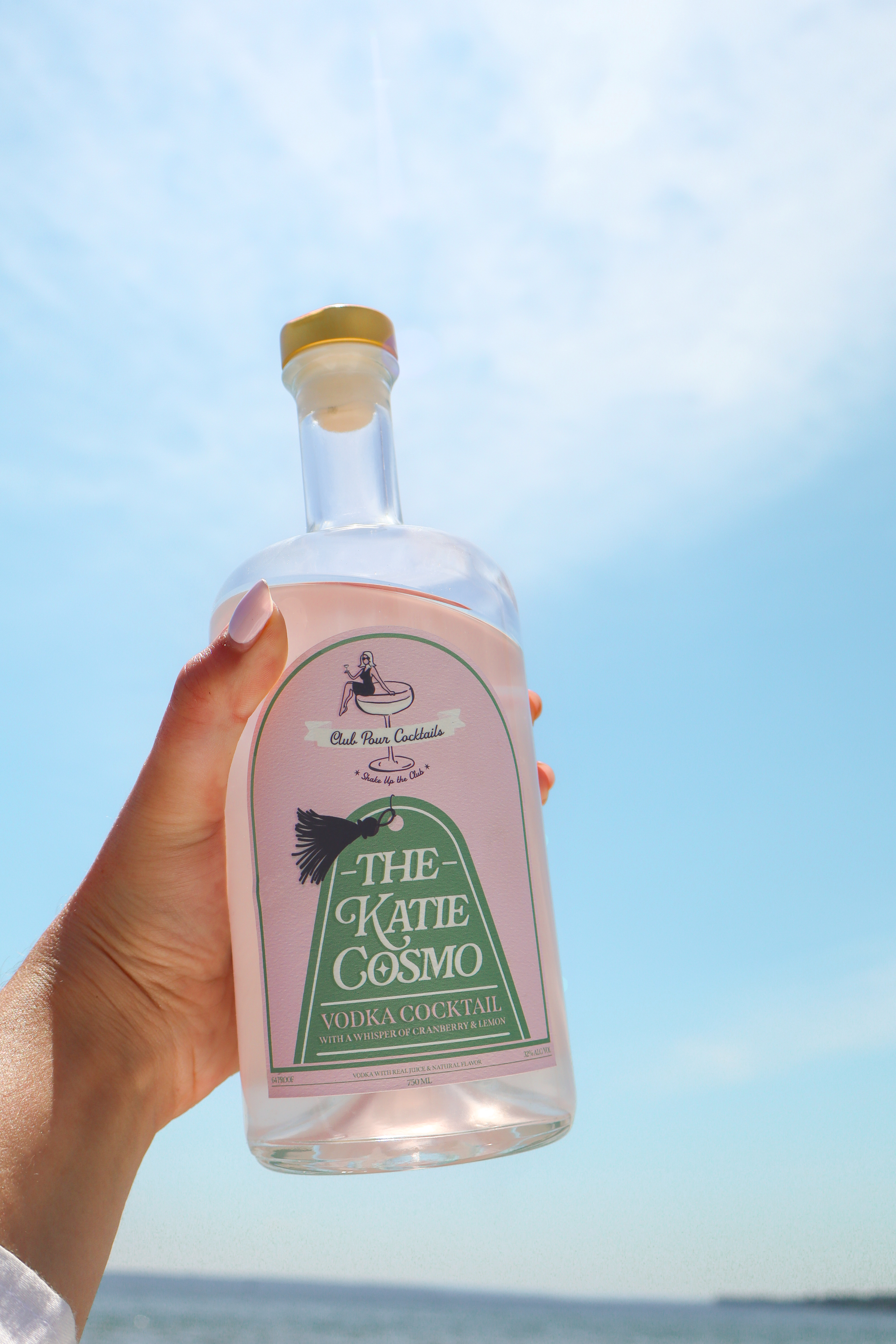 The Katie Cosmo bottle held up against a blue sky